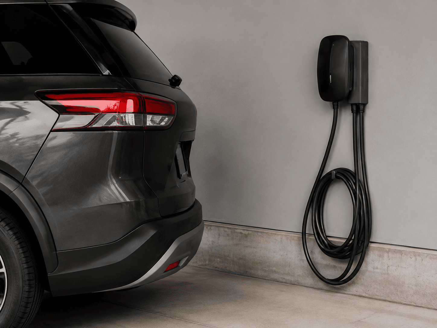 Electric vehicle at its regular parking location beside a wall charger