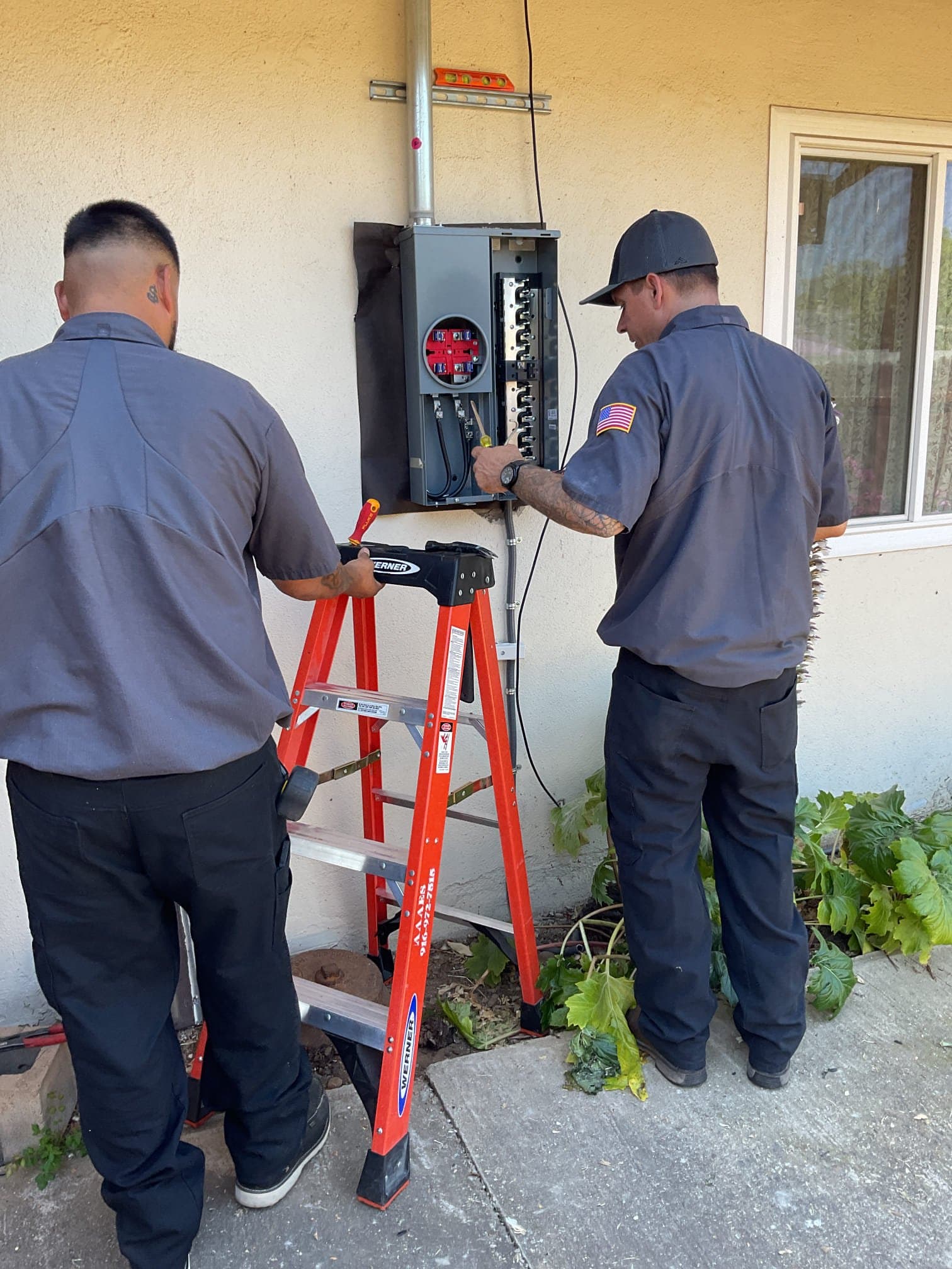 AAA Electrical Services technicians working at an exterior electrical panel